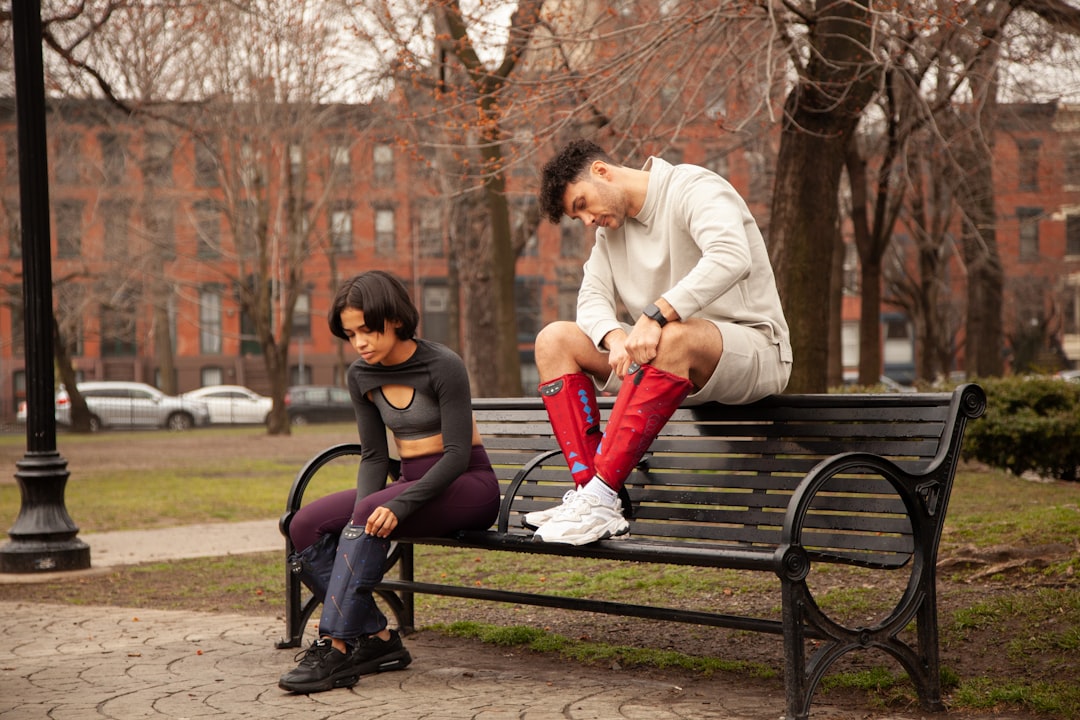 man and woman sitting on bench during daytime